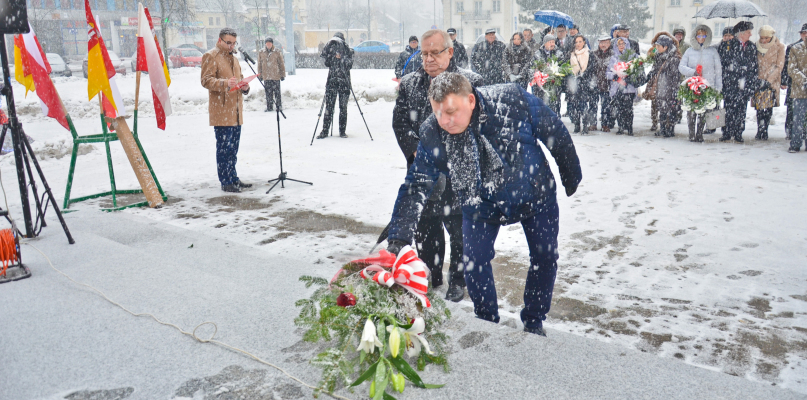 Kwiaty przed pomnikiem Żołnierza Polskiego składa szef klubu radnych SLD, Jarosław Hupało. Z tyłu stoi Stanisław Wawrzonkoski. fot. Łukasz Daniewski